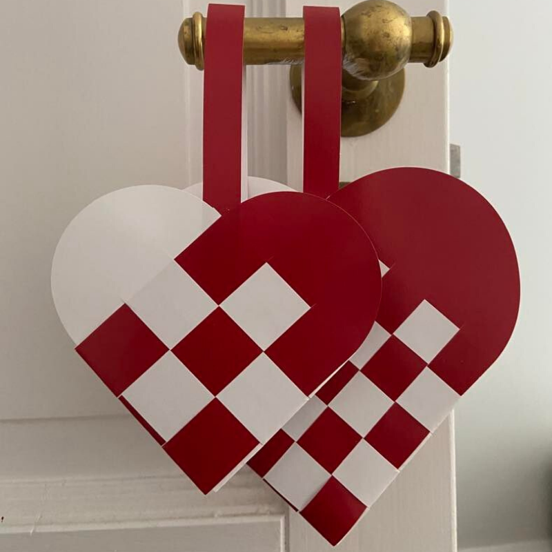 Two sizes of traditional red and white woven Danish Christmas hearts