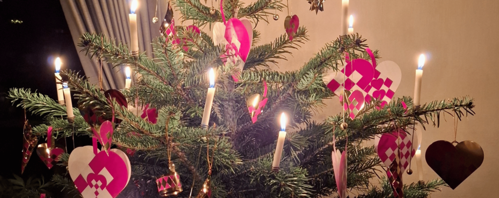 Flettede julehjerter i glanspapir hængende på et juletræ – dansk juletradition fra Ugly Duckli