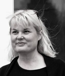 Sort/hvidt portræt af Rikke V. Stoltz i close-up. Udstråler ro, nærvær og refleksion – et ærligt øjeblik med øjenkontakt, der inviterer til tillid.